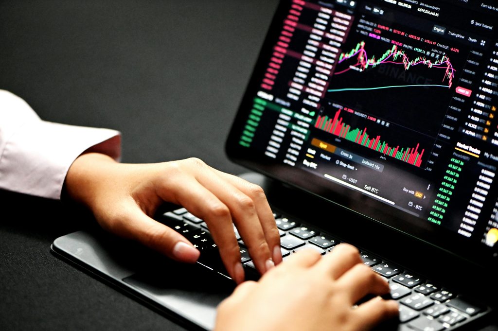 Hands on a laptop keyboard with a trading screen open